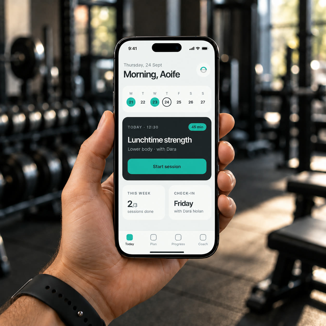 A hand holding a phone with the ORTUS app open on today's session, in a training studio.